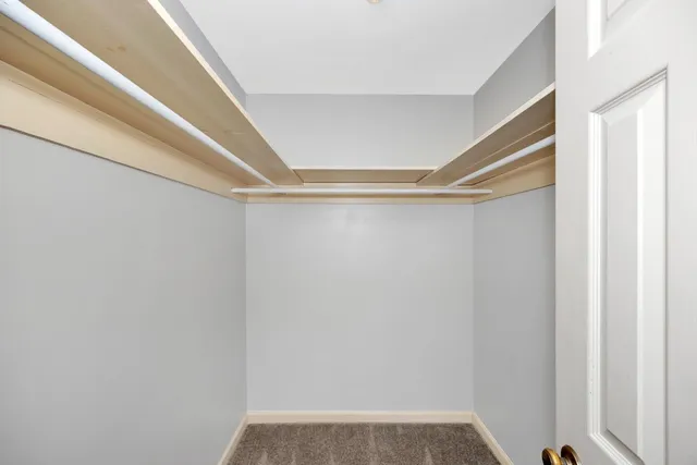 a view of walk in closet with empty racks