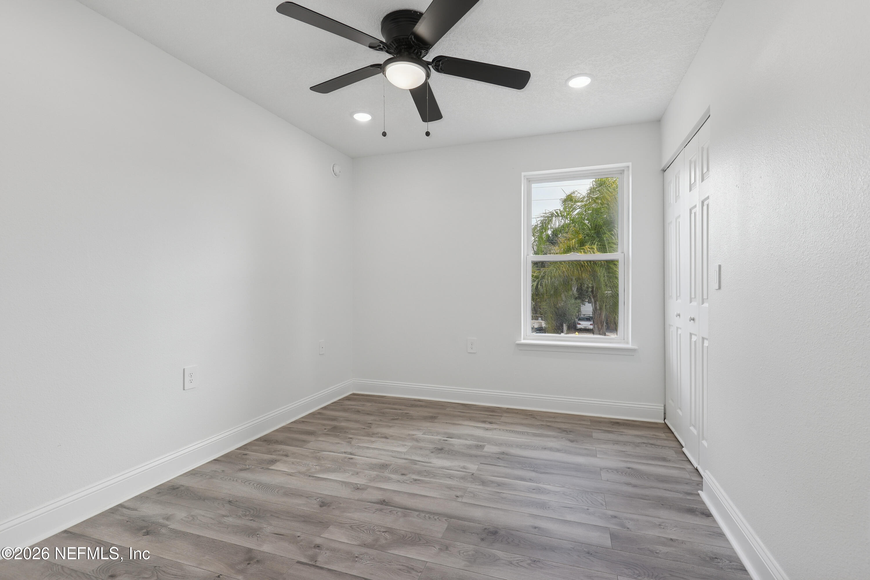 1022 Penman Road Jacksonville Beach, FL 32250 - Photo 33 of 52 an empty room with wooden floor fan and windows