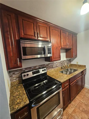 a kitchen with granite countertop a stove and a microwave