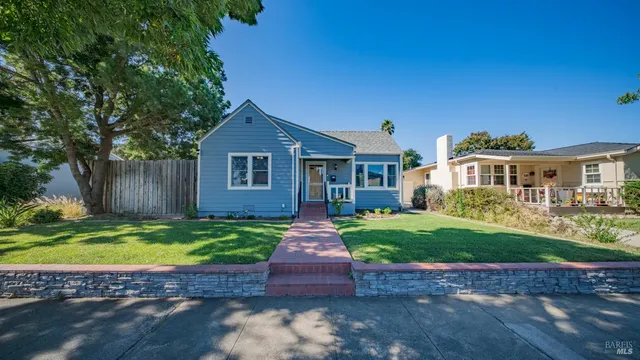a front view of a house with a garden and yard