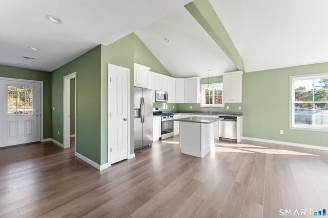 a kitchen with granite countertop a stove top oven a sink dishwasher and a refrigerator