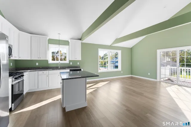 a kitchen with granite countertop a sink and white cabinets