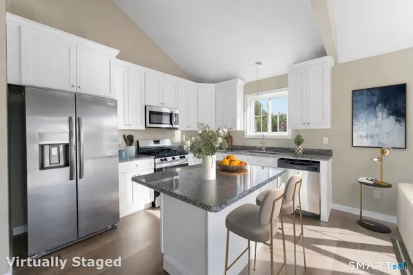 a kitchen with granite countertop a stove top oven a sink dishwasher and a refrigerator