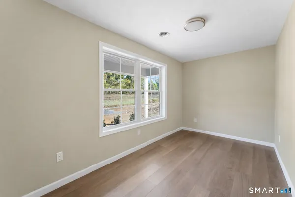 a kitchen with stainless steel appliances granite countertop a refrigerator a stove a sink a dining table and chairs with wooden floor