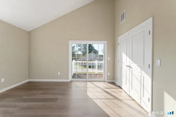 an empty room with wooden floor and windows