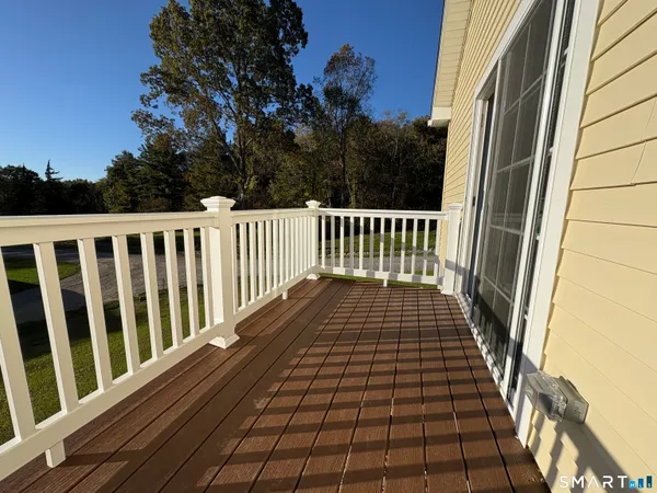 a view of balcony with wooden floor and fence
