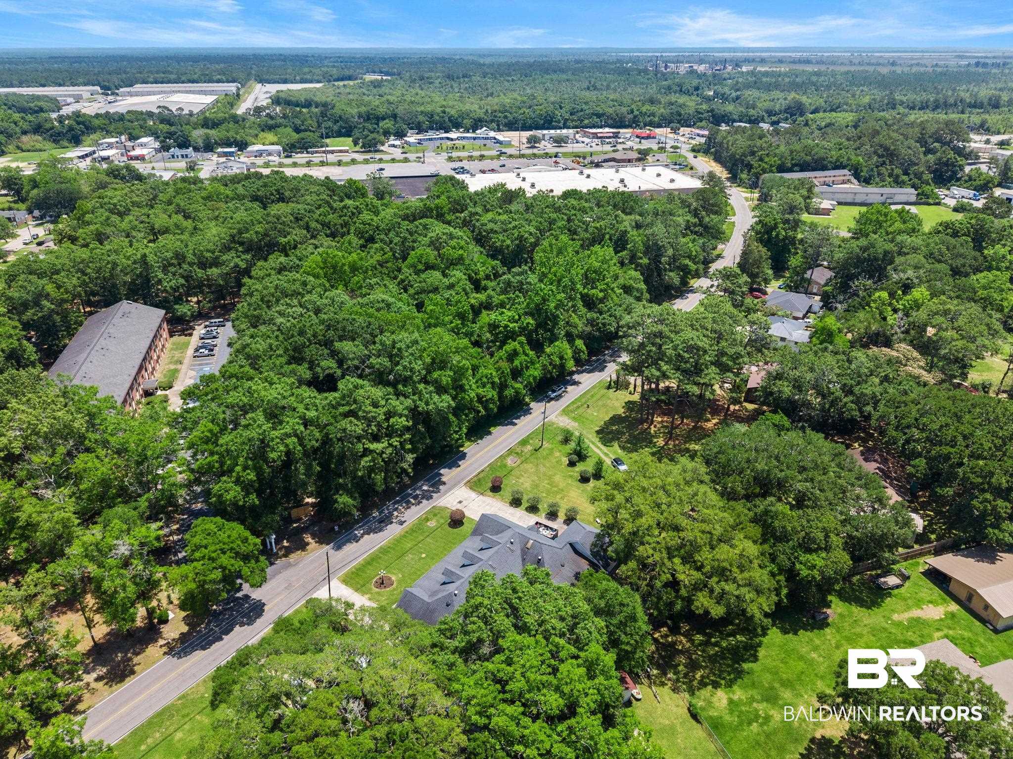 927 Cleveland Road Saraland, AL 36571 - Photo 66 of 80 Aerial perspective showcasing a residential and commercial area surrounded by extensive tree coverage