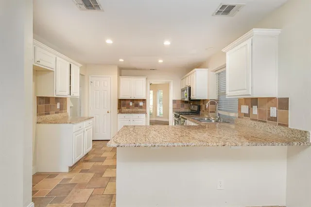 a large kitchen with kitchen island granite countertop a large counter top stainless steel appliances and cabinets
