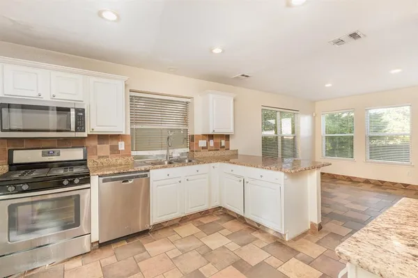 a kitchen with a sink stove and microwave