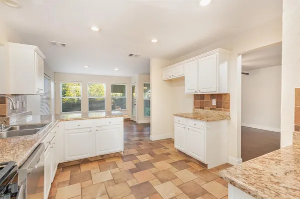 a large white kitchen with a stove a sink and a refrigerator