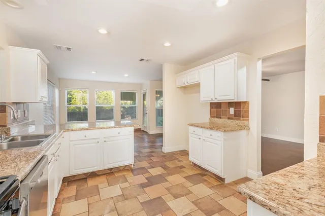 a large white kitchen with a stove a sink and a refrigerator
