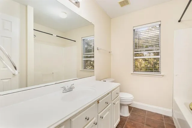 a bathroom with a sink a toilet and a window
