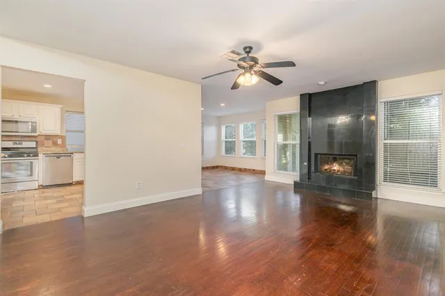a view of a hallway with wooden floor and a kitchen