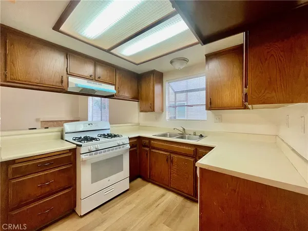 a kitchen with stainless steel appliances granite countertop wooden cabinets sink and stove top oven