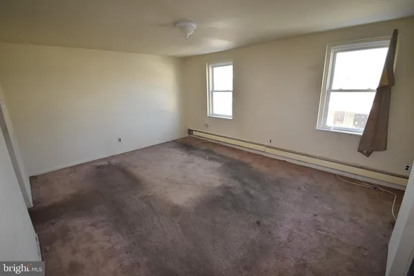 an empty room with windows and closet