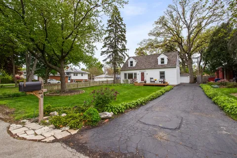 a front view of a house with a yard and shrubs
