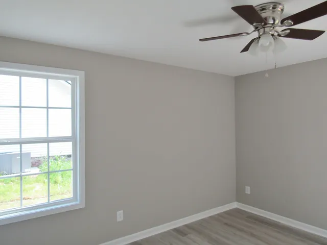 an empty room with a window and a fan