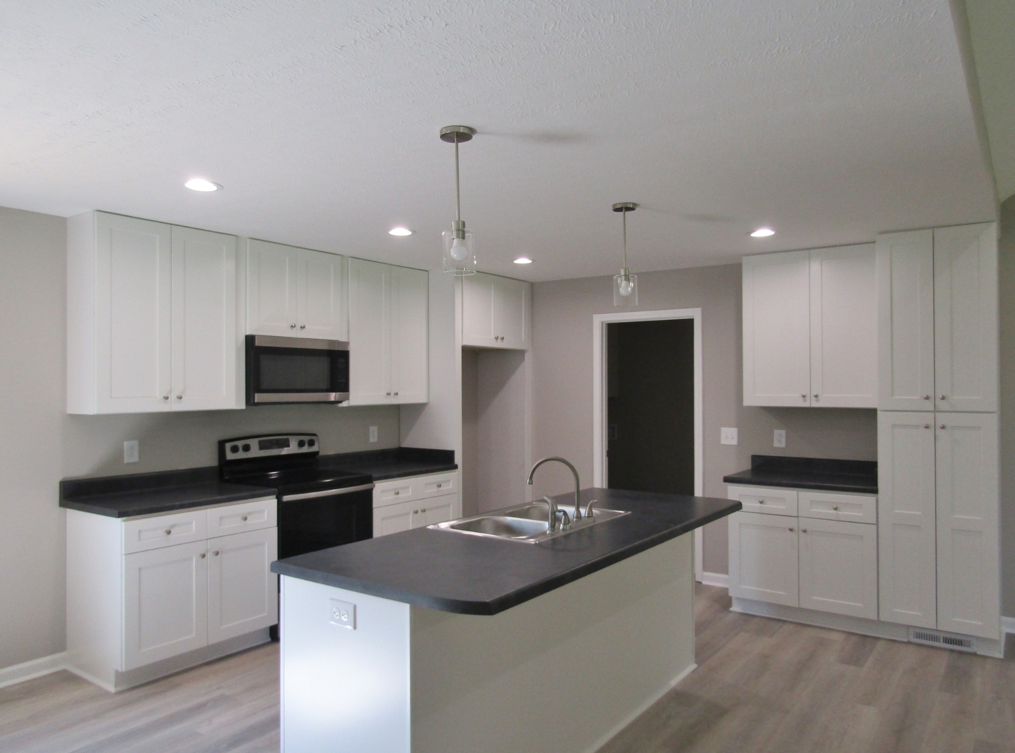 306 Ostella Road Cornersville, TN 37047 - Photo 5 of 15 a kitchen with stainless steel appliances granite countertop a sink a stove and microwave