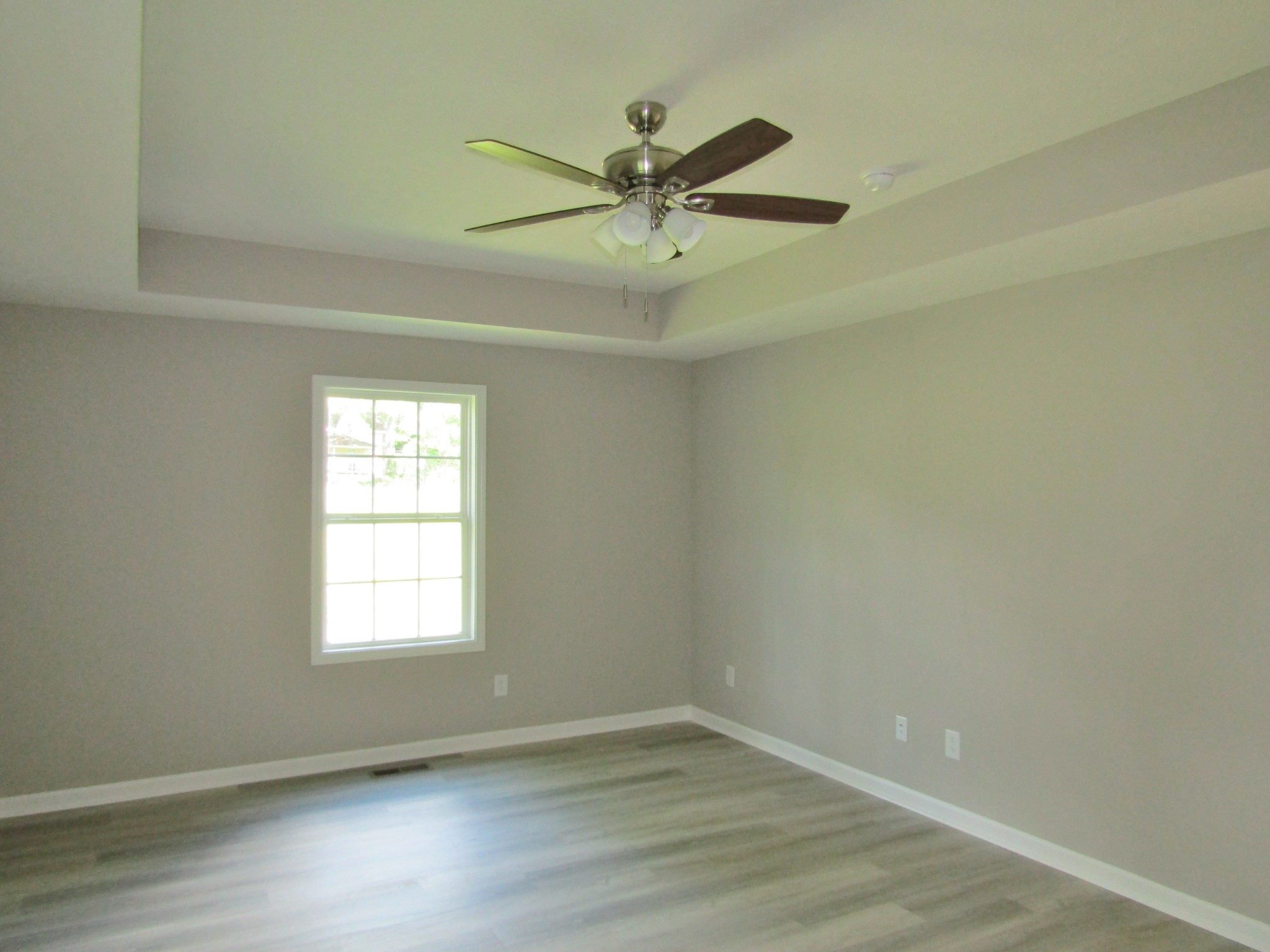 306 Ostella Road Cornersville, TN 37047 - Photo 9 of 15 an empty room with wooden floor fan and windows