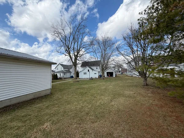 a view of garage with a white house
