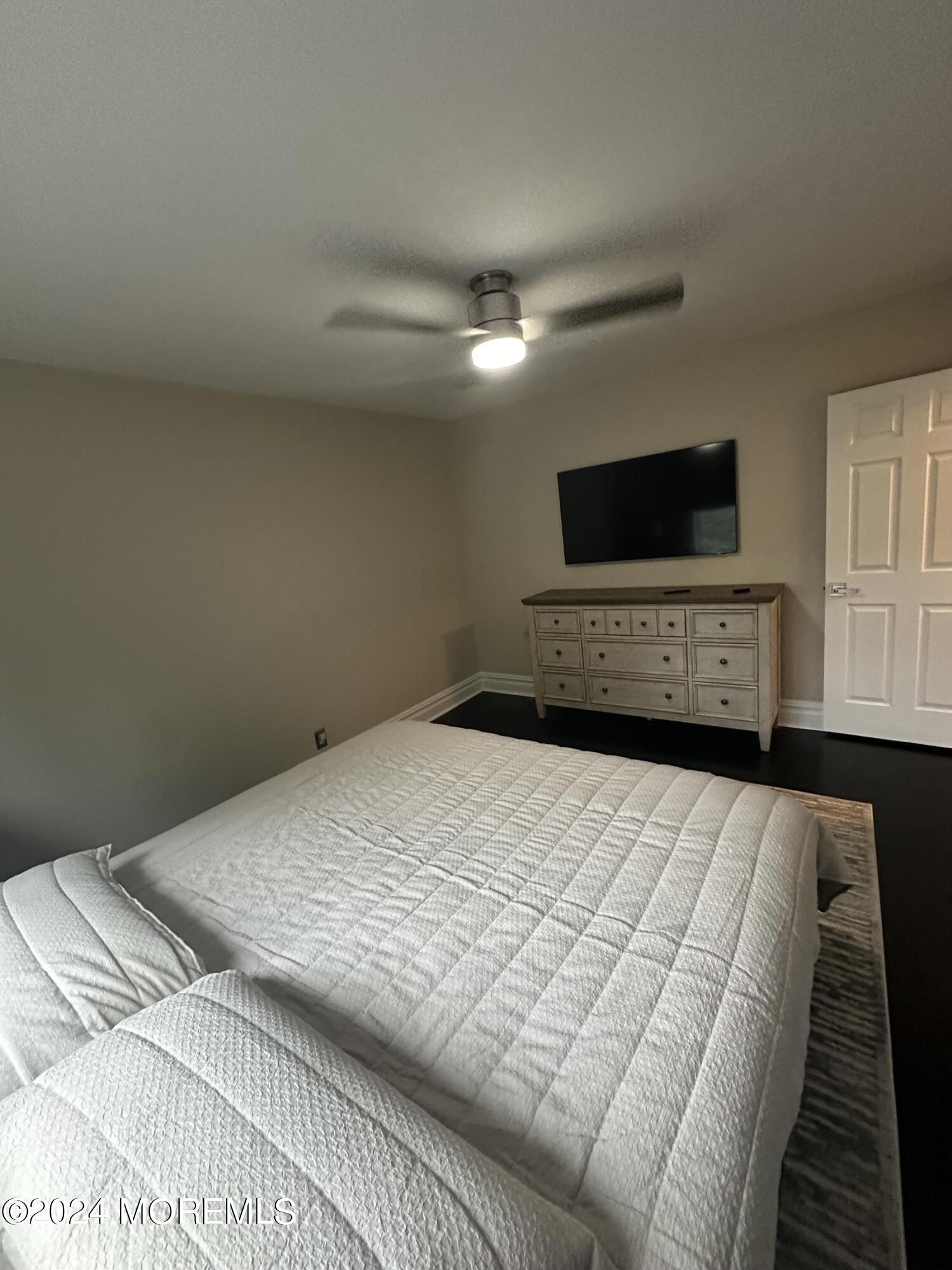 283 Spring Street, Unit 3D Red Bank, NJ 07701 - Photo 13 of 18 a bedroom with a bed and a flat screen tv