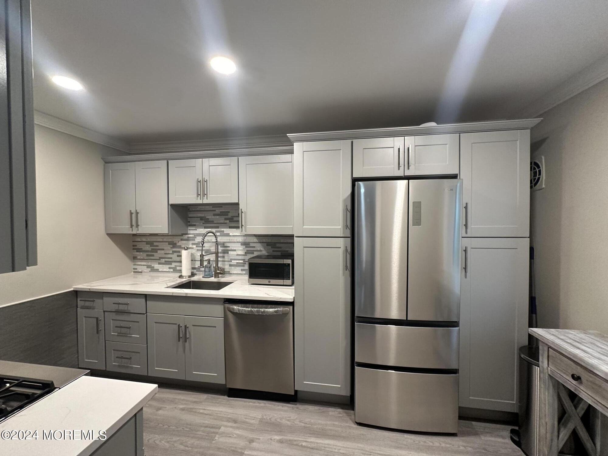 283 Spring Street, Unit 3D Red Bank, NJ 07701 - Photo 5 of 18 a kitchen with stainless steel appliances a refrigerator and a sink