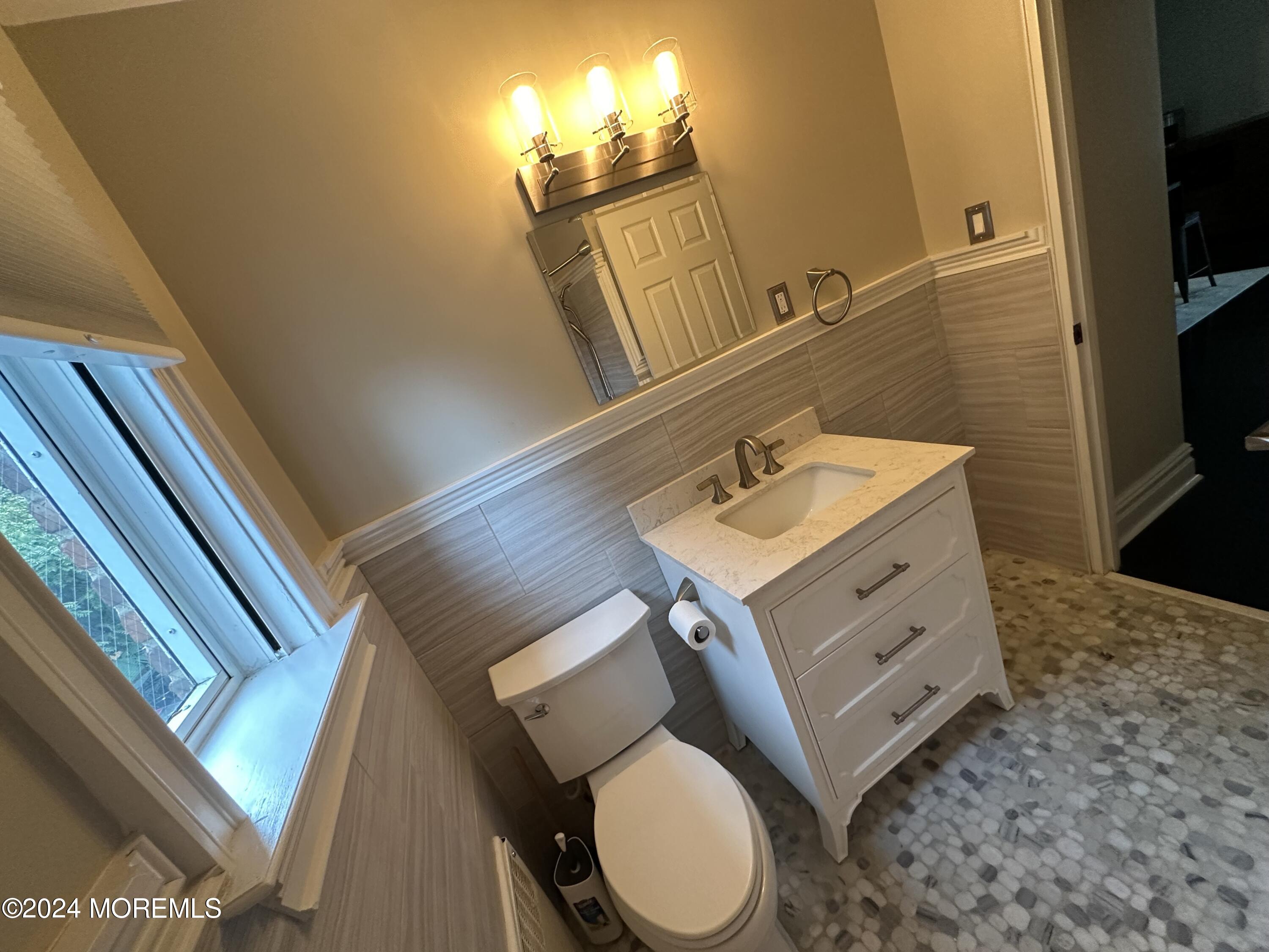 283 Spring Street, Unit 3D Red Bank, NJ 07701 - Photo 10 of 18 a bathroom with a toilet sink and mirror