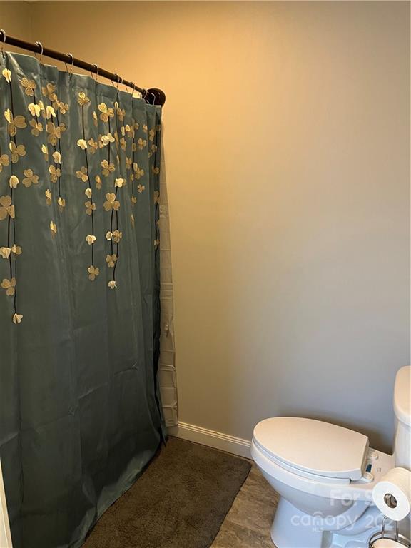 2419 Winfield Street Kannapolis, NC 28083 - Photo 10 of 25 a white toilet sitting next to a shower curtain