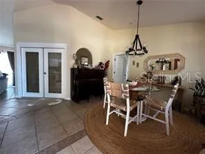 a view of a dining room and livingroom with furniture wooden floor a chandelier
