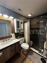 a bathroom with a sink a toilet a mirror and shower