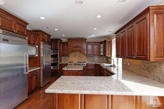 57 Highland Road Simi Valley, CA 93065 - Photo 12 of 46 a kitchen with kitchen island granite countertop wooden cabinets a refrigerator and a sink