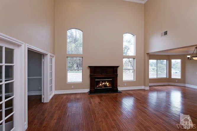 57 Highland Road Simi Valley, CA 93065 - Photo 8 of 46 an empty room with wooden floor a fireplace and windows