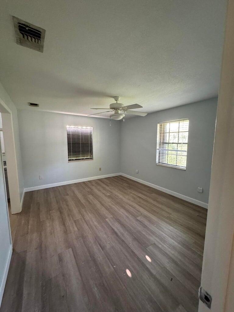 13529 42nd Road North West Palm Beach, FL 33411 - Photo 5 of 11 wooden floor in an empty room with a window