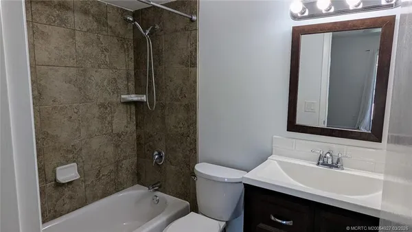 an empty room with a ceiling fan and a window