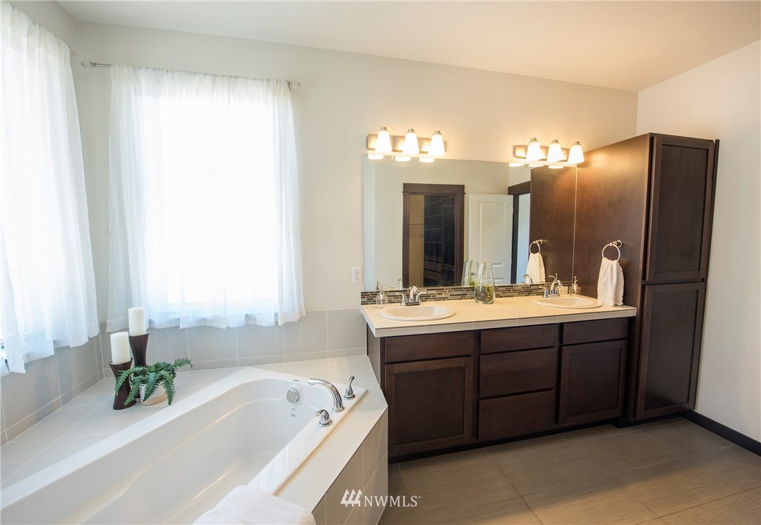 17409 3rd Avenue Southeast Bothell, WA 98012 - Photo 14 of 26 a bathroom with a tub a double vanity sink and a mirror