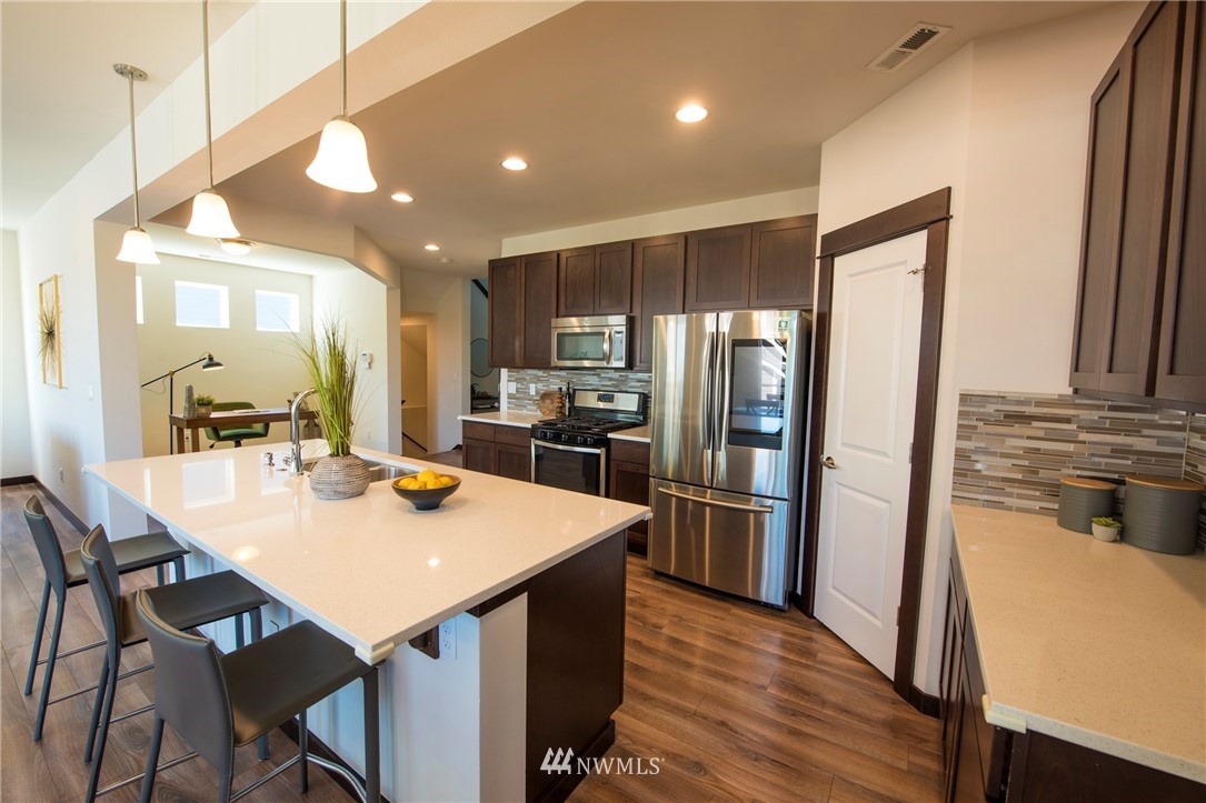 17409 3rd Avenue Southeast Bothell, WA 98012 - Photo 9 of 26 a kitchen with stainless steel appliances granite countertop a refrigerator a stove a sink a dining table and chairs