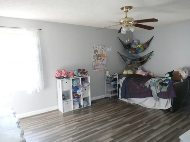 a view of a room with wooden floor and ceiling fan