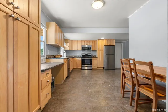 a kitchen with stainless steel appliances a refrigerator and a stove top oven