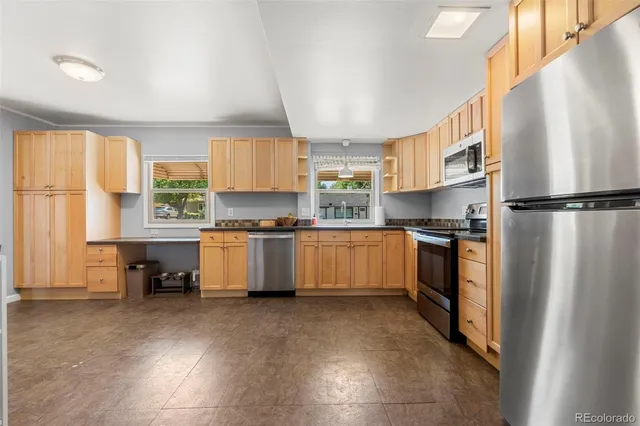 a kitchen with white cabinets and refrigerator