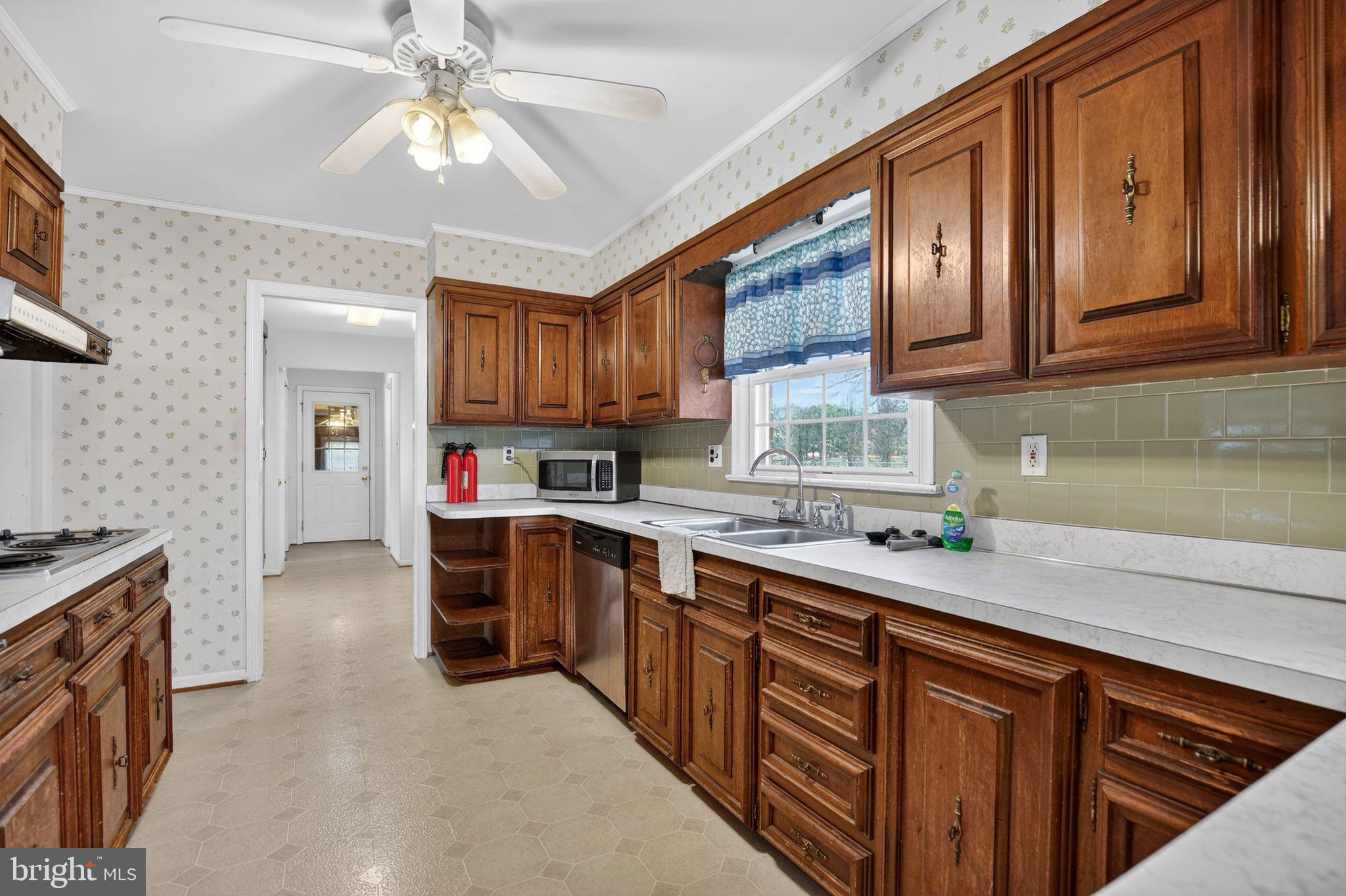 7146 Leonardtown Road Hughesville, MD 20637 - Photo 21 of 34 a kitchen with stainless steel appliances granite countertop a sink stove and cabinets
