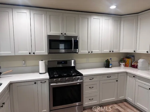 a kitchen with white cabinets and white appliances