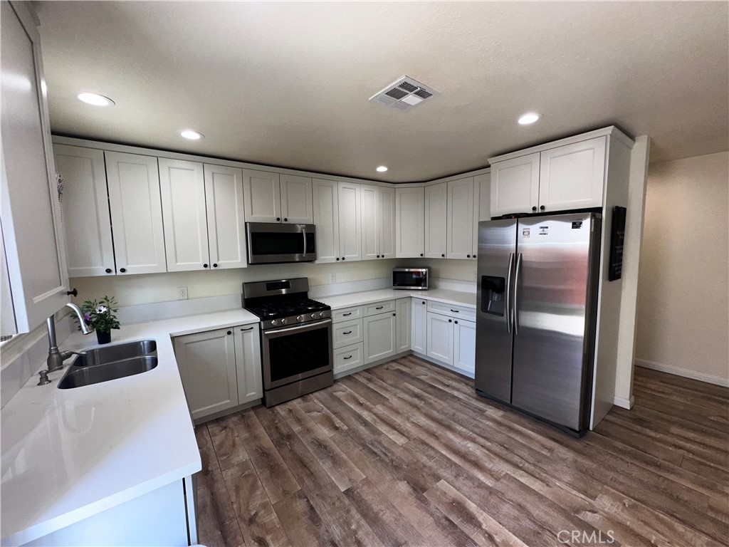 1050 Athena Court Riverside, CA 92507 - Photo 4 of 12 a kitchen with granite countertop a refrigerator stove and microwave