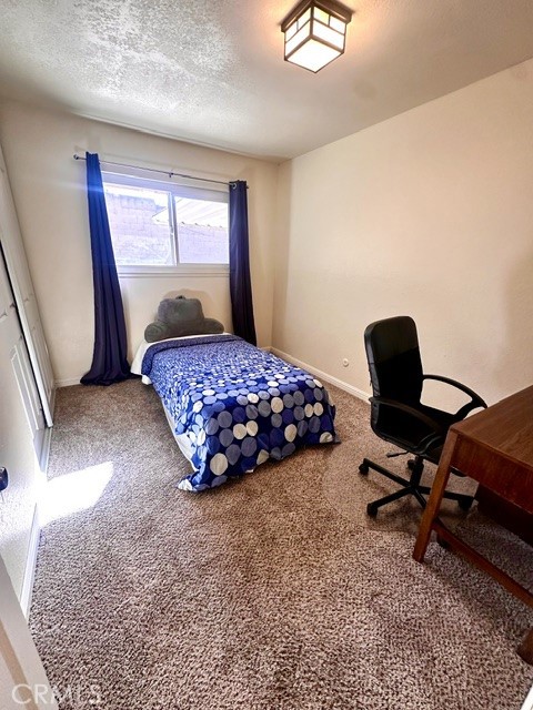 1050 Athena Court Riverside, CA 92507 - Photo 8 of 12 a bedroom with a bed a desk and chair