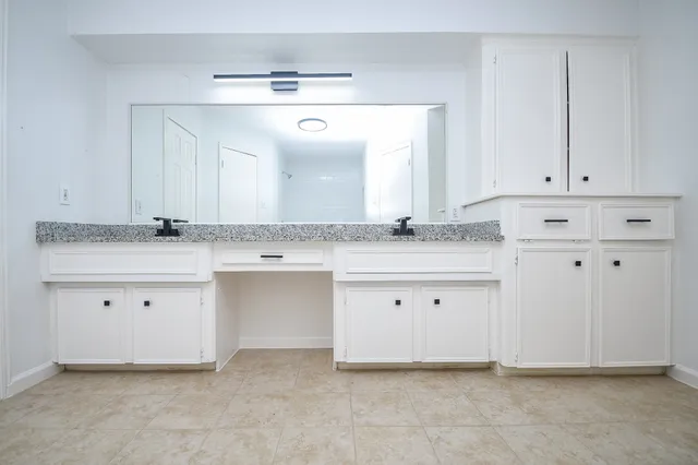 a view of a kitchen with granite countertop white cabinets and a sink