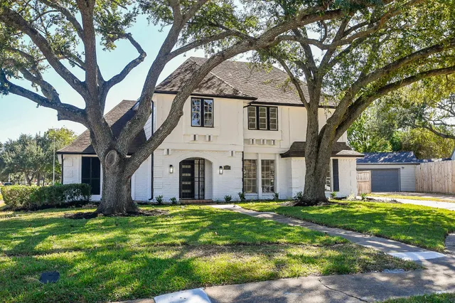 a view of house with yard and large trees