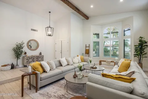 a living room with furniture painting on the wall and a window