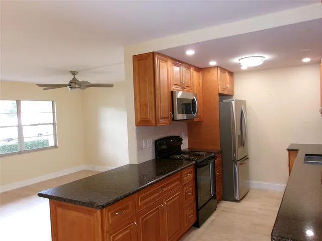 a kitchen with stainless steel appliances granite countertop a sink refrigerator and microwave