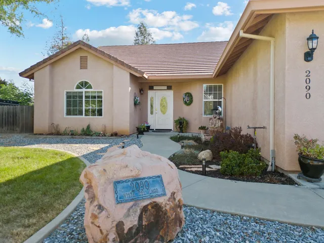 a front view of a house with a yard and potted plants
