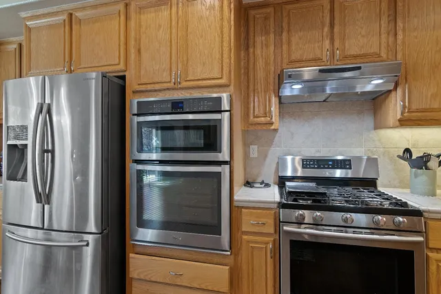 a kitchen with granite countertop stainless steel appliances and wooden cabinets