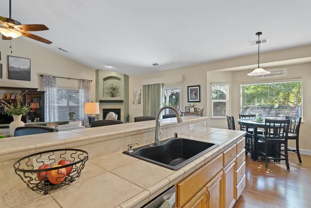 a kitchen with a stove a sink a dining table and chairs